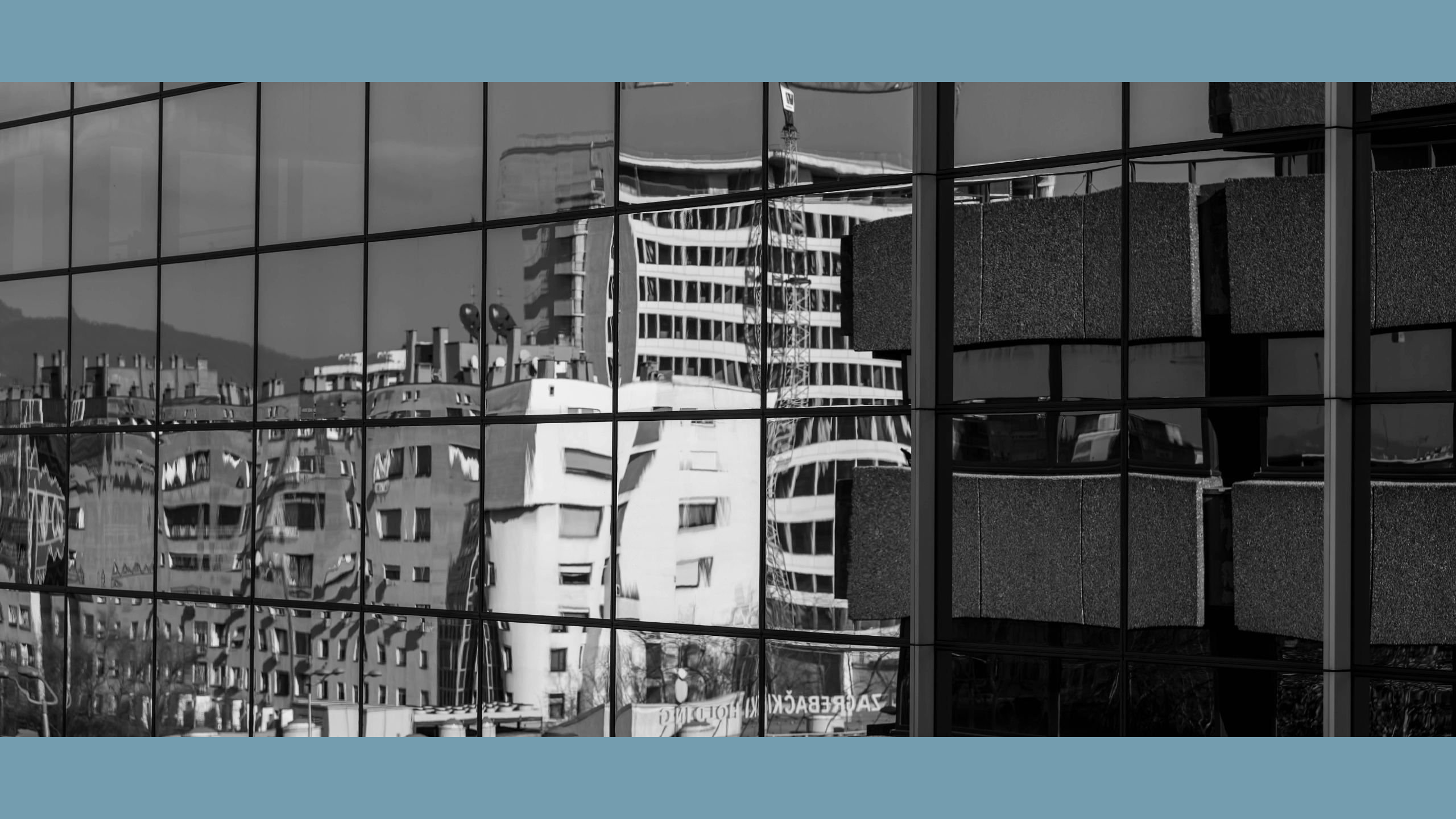 View of buildings slightly distorted in the reflection of a glass building. Black and white. Zagreb, Croatia